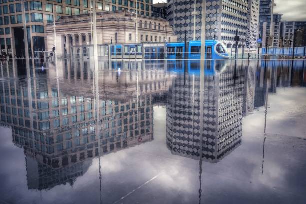 Birmingham, United Kingdom – March 21, 2021: A Centenary square reflection of tram against cityscape in Birmingham