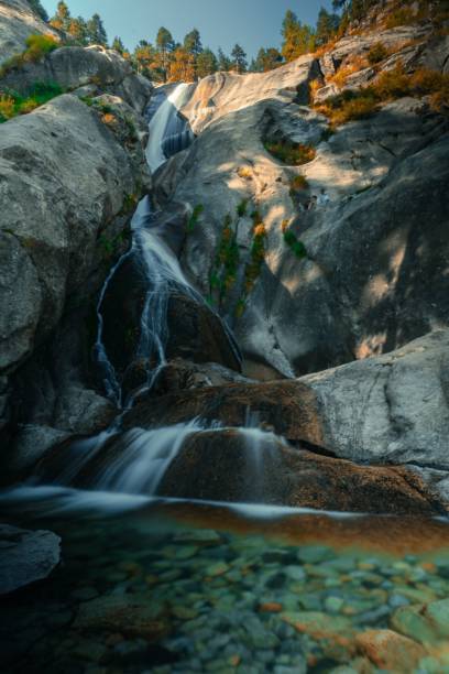 istock Vertical shot of a small waterfall going down the stones during the daytime 1447863007