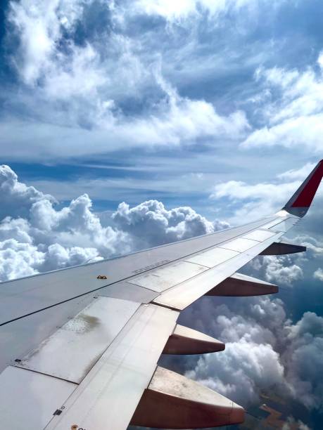 istock Vertical shot of fluffy clouds visible from an airplane window 1447866484