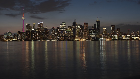 The illuminated Toronto city skyline at the night reflected in waters with long exposure