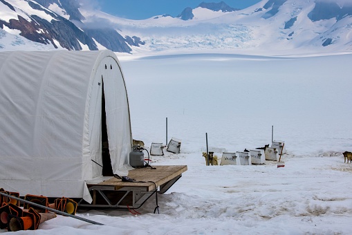 A tent and dog kennels by the Mendenhall Glacier in Juneau, Alaska
