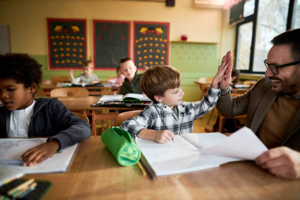 istock Happy teacher and schoolboy giving each other high-five on a class. 1447868885