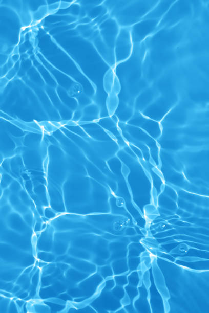 istock Defocus blurred transparent blue colored clear calm water surface texture with splashes and bubbles. Trendy abstract nature background. Water waves in sunlight with copy space. Blue watercolor shining 1447869697