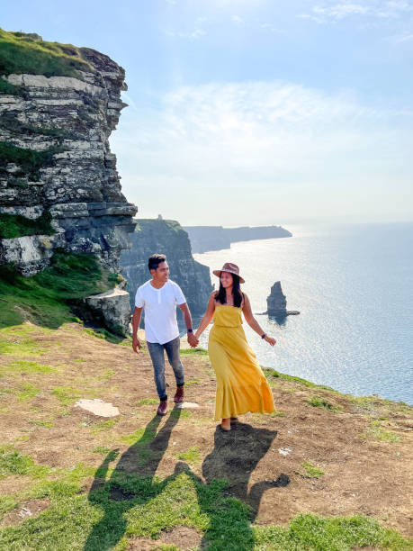 coppia diversa che viaggia in irlanda ed esplora la costa - sea coastline europe tourist foto e immagini stock