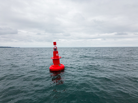 Red Navigational buoy in stormy sea with clouds slow motion