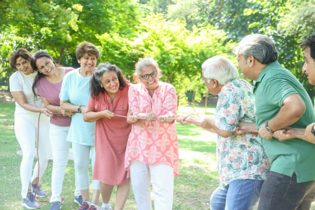 Group Of Senior Indian People Playing Tug War Outdoor In Park. Retirement life. Group Of Senior Indian People Playing Tug War Outdoor In Park. Retirement life. Social Interactions stock pictures, royalty-free photos & images