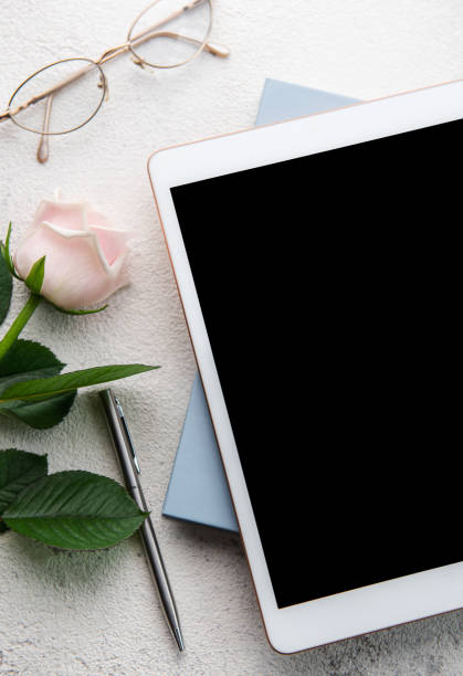 istock Bouquet of roses and tablet  on concrete background. 1447876143