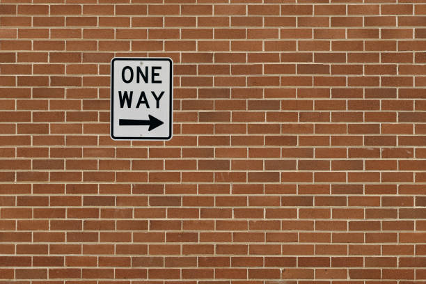 белый односторонний австралийский дорожный знак с текстом и стрелкой на кирпичной стене. - one way sign road blank стоковые фото и изображения