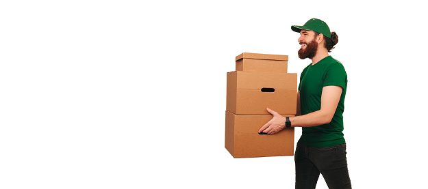 Side view studio shot of a powerful delivery man holding up some boxes while at work.