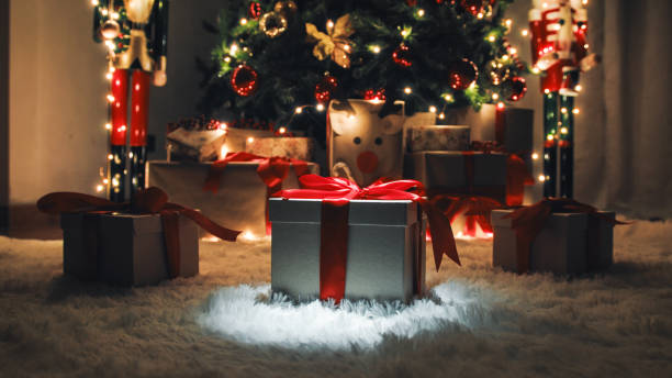 istock Three Christmas gift box on the white carpet with glowing lights 1447882877