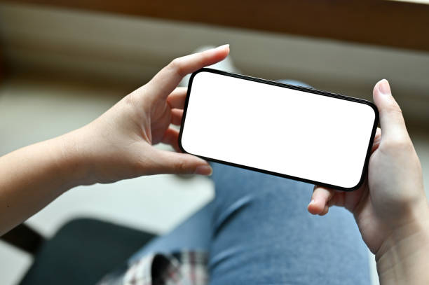 istock A female hands holding a smartphone white screen mockup in a horizontal position 1447884209