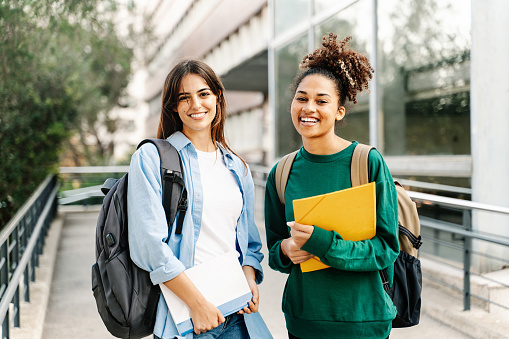 Dos amigas estudiantes universitarias sonriendo listas para las clases en el campus de la Universidad photo