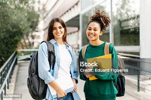 istock Two College Student female friends smiling ready for classes at the University campus 1447889800