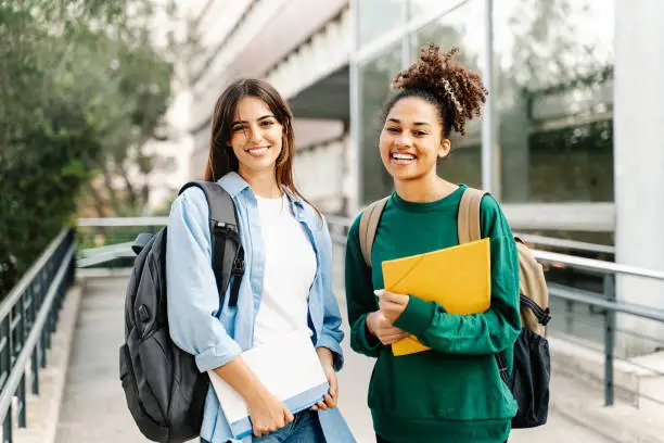 Two College Student female friends smiling ready for classes at the University campus