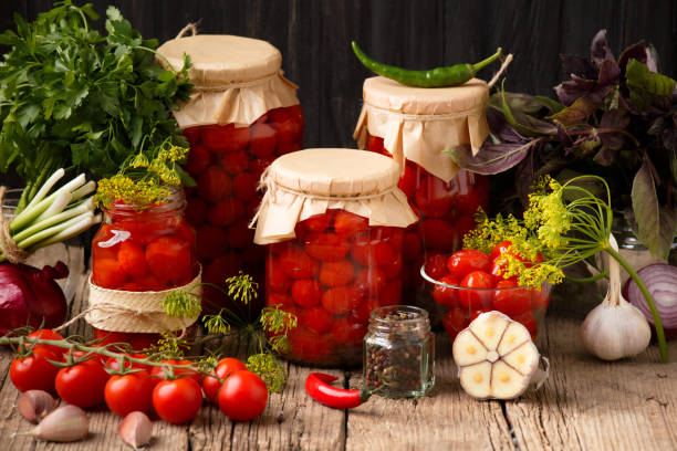 istock Jars with canned tomatoes on wooden background 1447889997