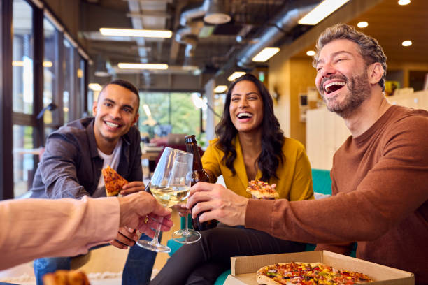 istock Staff At Informal Meeting In Office With Takeaway Pizza And Drinks 1447891047