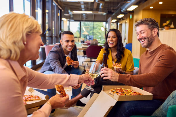 istock Staff At Informal Meeting In Office With Takeaway Pizza And Drinks 1447891050
