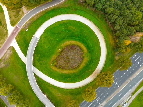 istock Bicycle path winding upwards over a bridge seen from above 1447891500