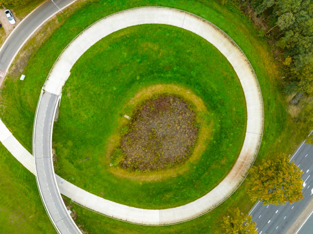 istock Bicycle path winding upwards over a bridge seen from above 1447891527