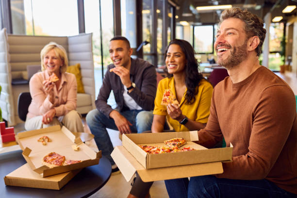 istock Staff At Informal Meeting In Office With Takeaway Pizza And Drinks 1447891744