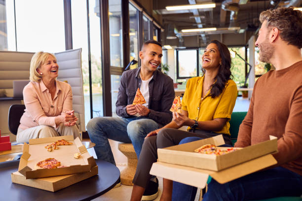 istock Staff At Informal Meeting In Office With Takeaway Pizza And Drinks 1447891746