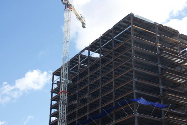 Downtown office building is under construction using scaffolding and cranes Downtown office building is under construction using scaffolding and cranes outdoor elevator stock pictures, royalty-free photos & images