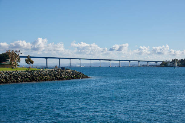 разбросанные облака по мосту и гавани залива коронадо - coronado bay bridge стоковые фото и изображения