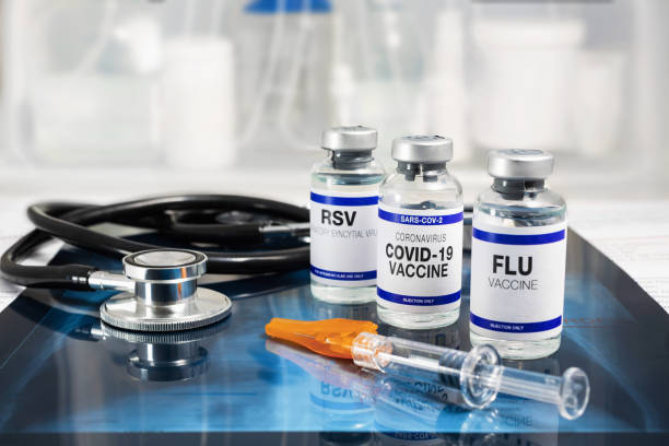 Flu, RSV and Sars-cov-2 Coronavirus vaccine vials in the medical clinic over Radiography pulmonar stock photo