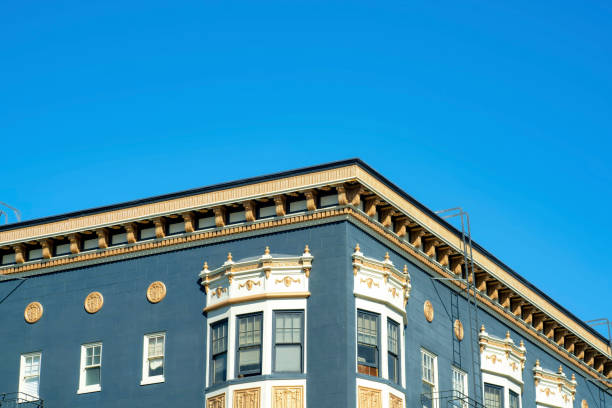 istock Blue stucco building with golden decorative facade with white accent paint around windows with flat roof and blue sky background 1447896226
