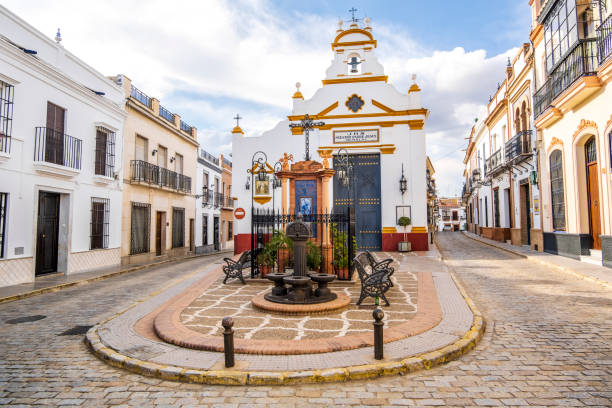 praça andaluza encantadora com igreja na cidade pequena, bullullos par del condado, spain - plaza de espana sevilla town square seville - fotografias e filmes do acervo