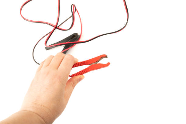 istock Jumper Cable in Hand Isolated, Battery Charger Clips, Car Problems Concept 1447899002