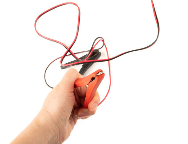 istock Jumper Cable in Hand Isolated, Battery Charger Clips, Car Problems Concept 1447899005