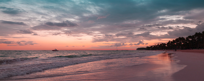 Atlantic Ocean coast on a sunrise, Bavaro beach, Dominican Republic. Panoramic coastal landscape with colorful cloudy sky