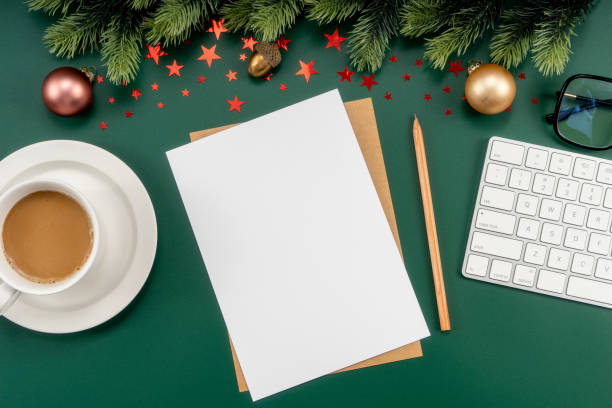 Mockup white notebook with pine branches and keyboard, christmas decorations on a green background stock photo