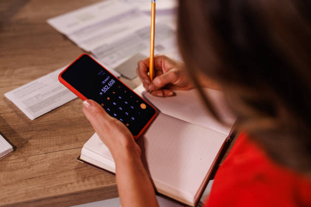 istock Woman using a calculator when doing finances at home office desk during Christmas holidays 1447905972
