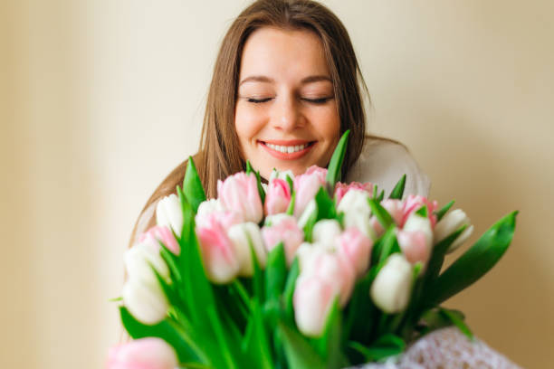 donna con bouquet di fiori primaverili. felice sorpresa donna modello che odora di fiori. festa della mamma. primavera - bouquet tulip flower nature foto e immagini stock