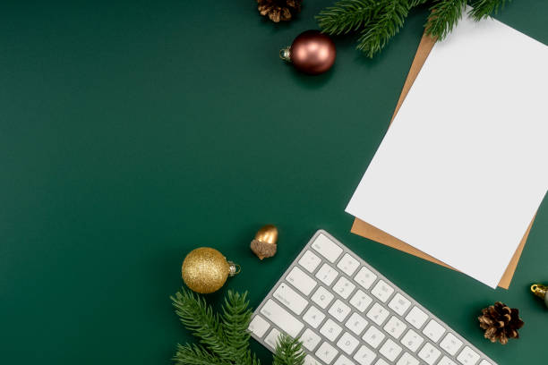 Home office table with Christmas decorations, keyboard, paper notebook. Christmas workspace. stock photo