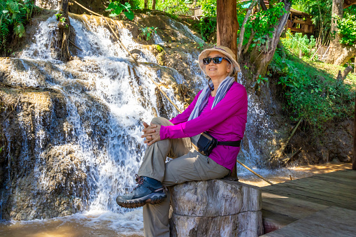 Woman traveller sitting at Nota Waterfall on the Myanmar border and flows into the Moei River. The border between Myanmar and Thailand