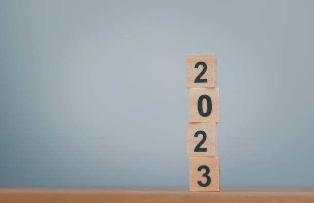 istock Happy New year 2023, numbers on wooden cube blocks stack on gray background with copy space. Welcome, Merry Christmas, warmly welcome, change year and Happy New Year in 2023. 1447910810