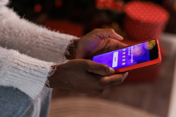 Cut out shot of woman doing online Christmas shopping via smart phone stock photo