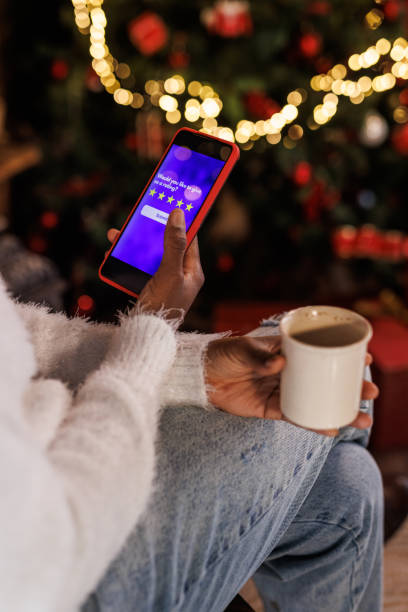 ausgeschnittene aufnahme einer frau, die per smartphone online weihnachtseinkäufe tätigt - communication discussion coffee christmas stock-fotos und bilder