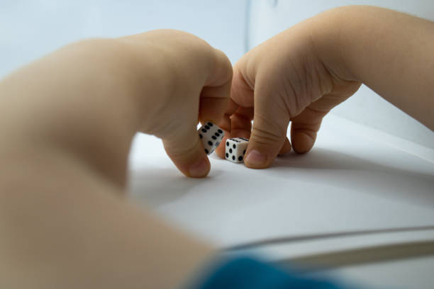 Hands holding a large pair of dice against a white background.