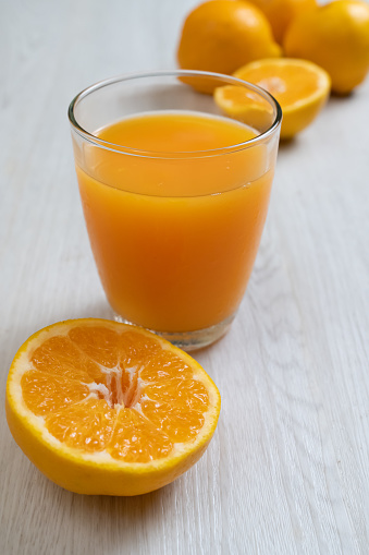 Glass of orange juice and oranges on a white background.  Other variations available.