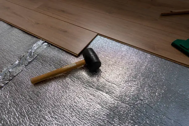 Laminate flooring a study with foil underlay and tools.