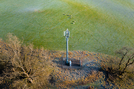 Aerial view from a drone of a mobile phone communication tower in a rural setting in Scotland