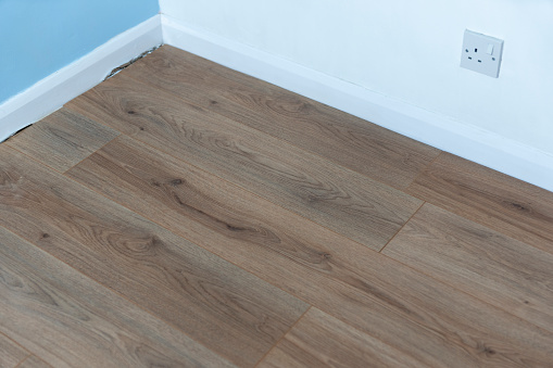 Laminate flooring a study. Corner fit with expansion gap.