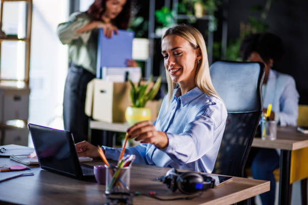 istock Young businesswoman reaching a pencil at her desk to write down notes while working 1447923404