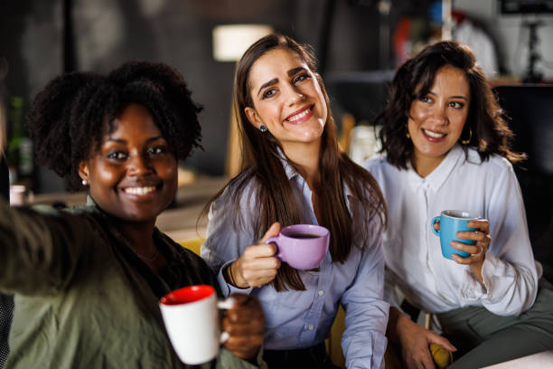 istock Three diverse businesswomen on a coffee break taking selfies together 1447924409