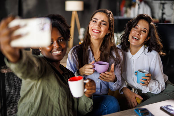 istock Three diverse businesswomen on a coffee break taking selfies together 1447924410