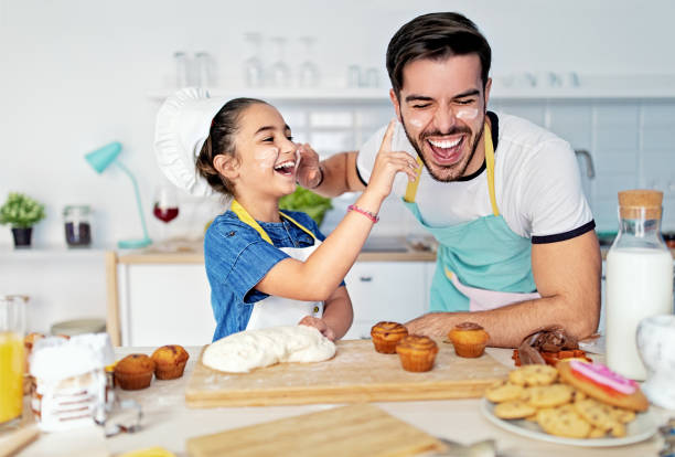 istock Father and daughter cooking together in a kitchen 1447929660
